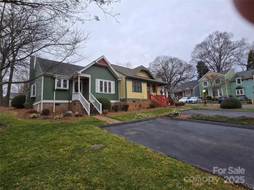 Charming multi-colored home boasts inviting front porch and well-maintained landscaping at 446 Windsor Ln, Statesville, NC 28677