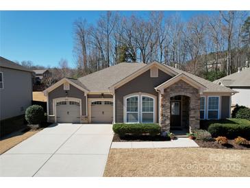 Single-story home with a stone archway entrance, a two-car garage, and verdant front yard landscaping at 5017 Willing Ct # 124, Indian Land, SC 29707