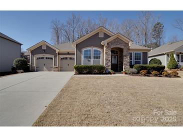 Charming single-story home featuring a stone archway, dual garage, and manicured front lawn at 5017 Willing Ct # 124, Indian Land, SC 29707