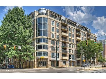 Contemporary multi-story condo building featuring large windows and balconies, with commercial spaces at street level at 718 W Trade St # 307, Charlotte, NC 28202