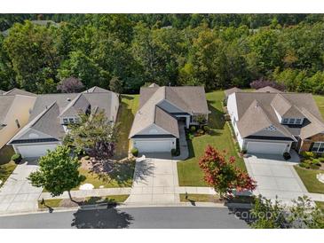 Aerial view of a well-maintained suburban home with manicured lawns and mature trees at 8107 Crater Lake Dr, Indian Land, SC 29707