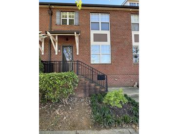 Charming brick townhome featuring a quaint front entrance and well-maintained landscaping at 121 Irving Ave, Mooresville, NC 28117