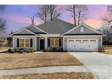 Charming one-story home with attached garage, landscaped yard, and neutral siding, perfect for modern living at 156 Sugar Hill Rd, Troutman, NC 28166
