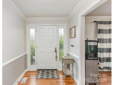 Inviting entryway with hardwood floors, decorative molding, and a front door with glass sidelights at 2156 Flynn Dr, Gastonia, NC 28054