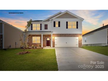 Two-story home boasts brick and siding accents, a well-manicured lawn, and a two-car garage at 469 Court House Ave, York, SC 29745