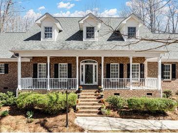 Charming brick home with a welcoming front porch, white columns, black shutters, and well-manicured landscaping at 501 Colonels Ct, Clover, SC 29710