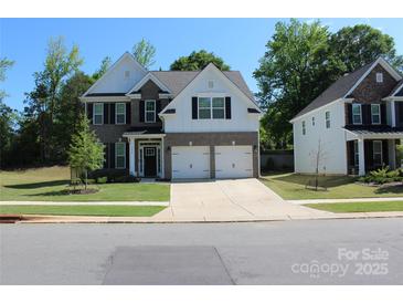 Charming two-story home with a two car garage, well-manicured lawn and neutral color scheme at 5056 Blue Serenity Ct, Denver, NC 28037