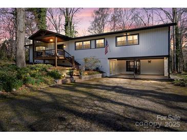 Inviting exterior elevation showcases a covered porch, open carport, and lovely landscaping at dusk at 910 Forest Dr # 14, Lancaster, SC 29720