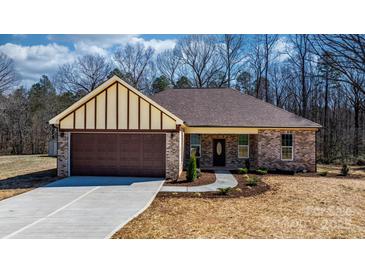 Charming brick home featuring a covered entrance, attached garage, and well-manicured lawn at 105 4Th Se St, Catawba, NC 28609