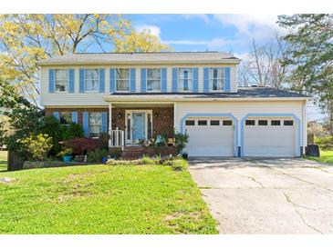 Charming two-story home featuring a well-maintained lawn, attached two-car garage, and light-blue shutters at 11416 Leadenhall Ln # 22, Charlotte, NC 28262