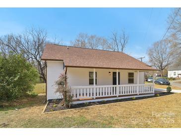 Charming home featuring a covered front porch, light colored siding, and a well-maintained lawn at 1156 9Th St, Lancaster, SC 29720