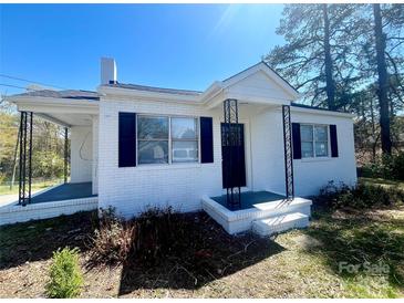 Charming, painted brick home featuring black shutters, and inviting porch at 1408 Linwood Rd, Gastonia, NC 28052