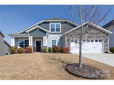 Charming home featuring stone accents, a two-car garage, and inviting front porch with manicured landscaping at 2296 Idol Rock Dr, Indian Land, SC 29707