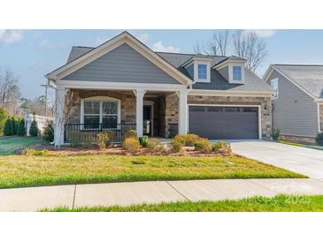 Charming single-Gathering home with a stone and siding facade and a well-manicured lawn at 1005 Headwaters Ct, Matthews, NC 28104