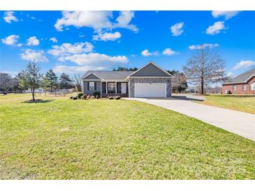 Charming single-story home featuring stone accents, a two-car garage, and a beautifully manicured lawn at 1429 Scotts Creek Rd, Statesville, NC 28625