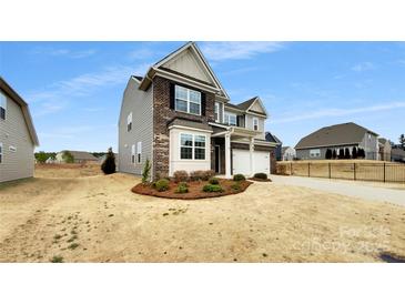 Two-story home featuring a mix of gray siding and brick accents, complemented by a well-manicured lawn at 151 Slip Shot Ln, Troutman, NC 28166