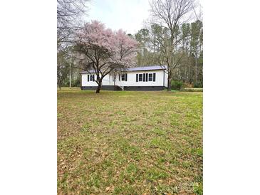 Charming home with a well-maintained lawn and beautiful, mature trees creating a welcoming entrance at 1607 W Nc 27 Hwy, Lincolnton, NC 28092