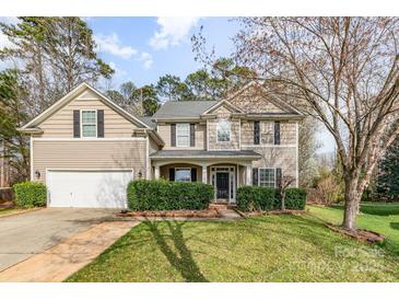 Charming two-story home boasts a well-manicured lawn and a welcoming front porch, perfect for enjoying the outdoors at 2157 Tommy Ln, Matthews, NC 28105