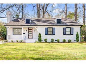 Charming white brick home with black shutters, well-manicured lawn and a modern glass door at 5009 Milford Rd, Charlotte, NC 28210