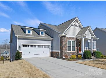 Charming home with a two-car garage, stone accents, and well-manicured landscaping, showcasing curb appeal at 5059 Saint Clair St, Fort Mill, SC 29715