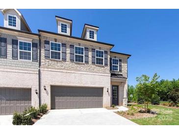 New construction townhome with a two-car garage and stone and brick facade at 104 Kentmore Dr, Waxhaw, NC 28173