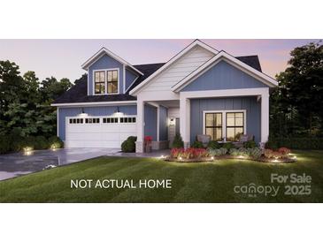 Charming two-story home featuring a spacious garage, inviting front porch, and professionally landscaped yard with exterior lighting at 135 Lake Cove Way # 64, Mooresville, NC 28115
