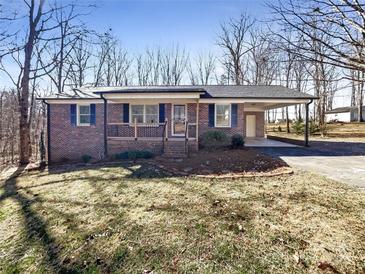 Charming brick ranch-style home featuring a covered carport and front porch, nestled on a spacious lot with mature trees at 1420 Hickory Nut Ln, Lincolnton, NC 28092