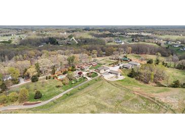 Expansive aerial view of a stunning home with a pool and multiple buildings on a large, lush, tree-lined property at 1620 London Rd, Mooresville, NC 28115