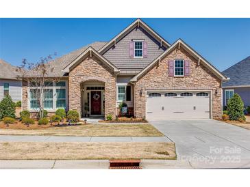 Charming stone facade home with a well-manicured front yard and a two-car garage at 17436 Langston Dr, Charlotte, NC 28278