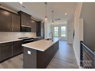 Modern kitchen features a central island with quartz countertops and stainless steel appliances at 2043 Clarksdale St # 31, Charlotte, NC 28206