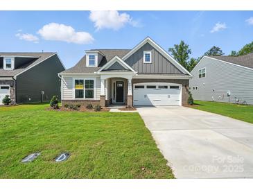 Charming two-story home with a manicured lawn, gray siding and a two-car garage at 4009 Grace Pointe Dr # 101, Indian Trail, NC 28079