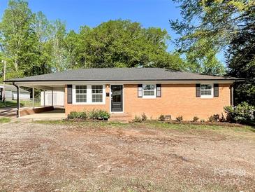 Charming brick home featuring classic black shutters and a convenient carport for covered parking at 418 Dallas Stanley Hwy, Dallas, NC 28034
