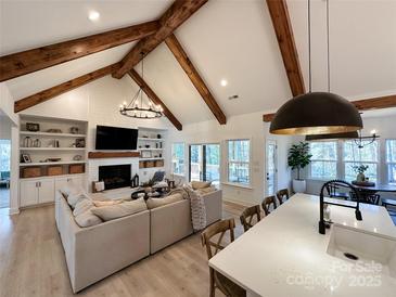 Bright living room featuring vaulted ceilings, exposed wooden beams, a fireplace, and an open floor plan at 856 Bellegray Rd, Clover, SC 29710