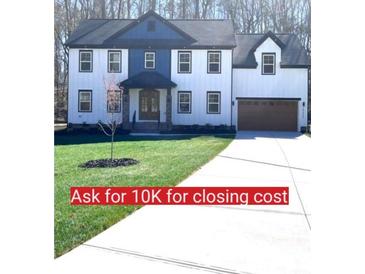 Stunning two-story home featuring a manicured lawn, a modern facade, and a long driveway leading to an attached garage at 10405 Briarhurst Pl # 18, Mint Hill, NC 28227