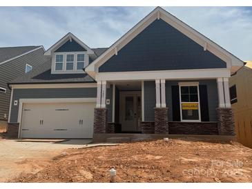 Charming single-Gathering home featuring a 2-car garage and a welcoming front porch with stone and siding accents at 121 N Prestwick Way # 43, Mooresville, NC 28115