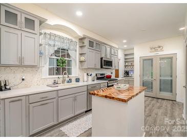 Modern kitchen with grey cabinetry, white countertops, stainless steel appliances, and a butcher block island at 1783 Reepsville Rd, Lincolnton, NC 28092