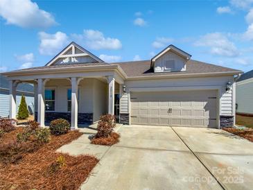 Charming single-story home boasts a two-car garage and inviting covered front porch and landscaped yard at 2018 Hyacinth Ct, Denver, NC 28037