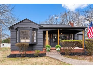 Charming single-story home featuring a covered front porch, brick accents, and neatly trimmed landscaping at 212 Sloan St, Belmont, NC 28012