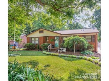 Charming brick home featuring mature trees and a lush green lawn at 4824 Harcourt Ln, Charlotte, NC 28212