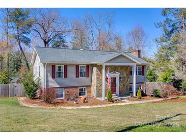Charming home featuring stone accents, a well-maintained lawn, and red shutters on a sunny day at 5230 Northview Dr, Hickory, NC 28601
