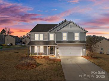 Charming two-story home with a covered porch and a two-car garage, showcasing its inviting curb appeal at 603 Smokehouse Ln, Albemarle, NC 28001