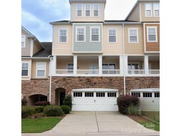 Inviting townhome with a stone facade, white garage door, and a covered porch at 609 Sunfish Ln, Tega Cay, SC 29708