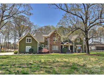 Expansive home with stone and wood exterior, professional landscaping, and a sprawling front lawn at 10209 New Town Rd, Marvin, NC 28173
