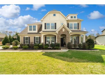 Beautiful two-story home with manicured lawn, stone accents, and welcoming front porch with tasteful landscaping at 1022 Torrens Dr, Monroe, NC 28110