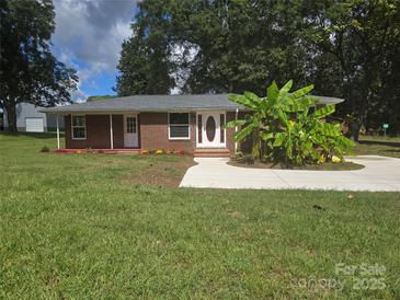 Charming brick home with a well-manicured lawn and a newly paved driveway at 245 College E Ave, Shelby, NC 28152