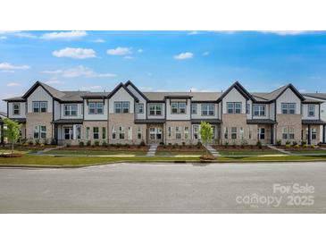 Modern townhome exterior showcasing brick and neutral siding, black trim, lush landscaping, and inviting curb appeal at 3105 Beacon Heights Rd, Indian Land, SC 29707