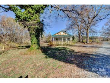 Charming single-Gathering home featuring a covered porch and spacious front yard surrounded by mature trees at 966 Marys Grove Rd, Cherryville, NC 28021