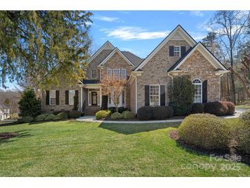 Beautiful two-story brick home featuring a manicured lawn and professional landscaping at 105 Elizabeth Brook Dr, Davidson, NC 28036