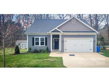 Charming home with well-maintained lawn, attached garage, and stylish curb appeal at 1123 Fieldstone Rd, Mooresville, NC 28115