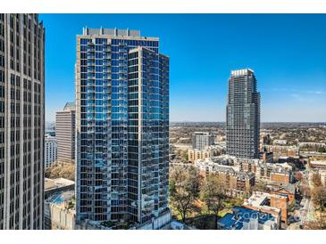 Stunning high-rise building with a glass facade and clear blue sky in this city view at 210 N Church St # 1507, Charlotte, NC 28202